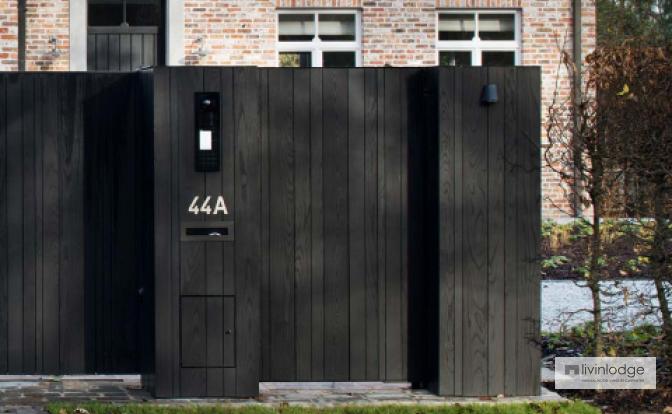 Portón de madera negro con puerta peatonal