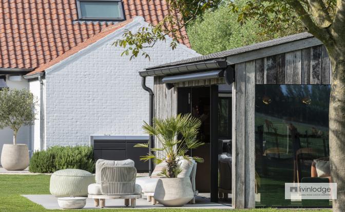 Decking with lounge area adjoining a garden room in Damme