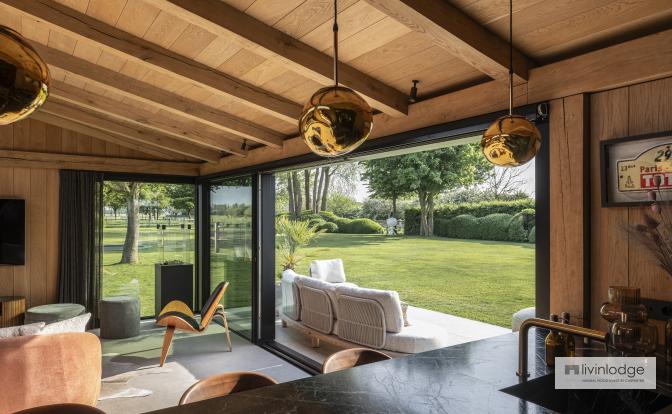 Interior with exposed roof boards and solid oak beams in a modern garden room
