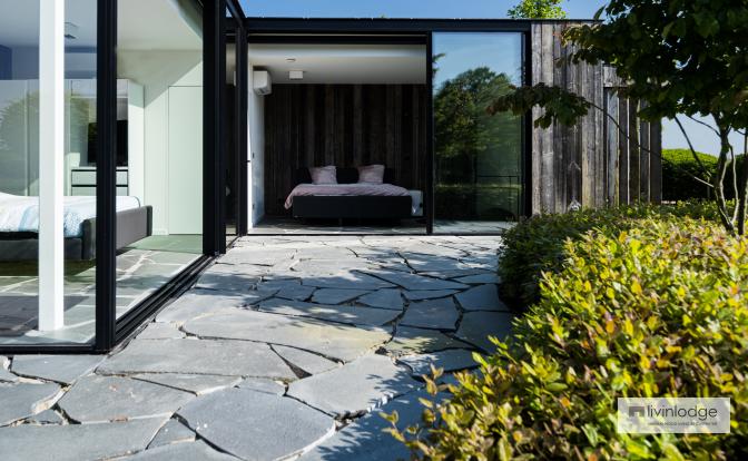 The guest space in the wooden outbuilding features large windows