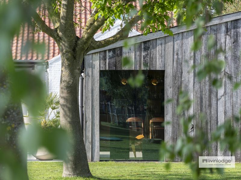Side view of a wooden outbuilding with barnwood cladding