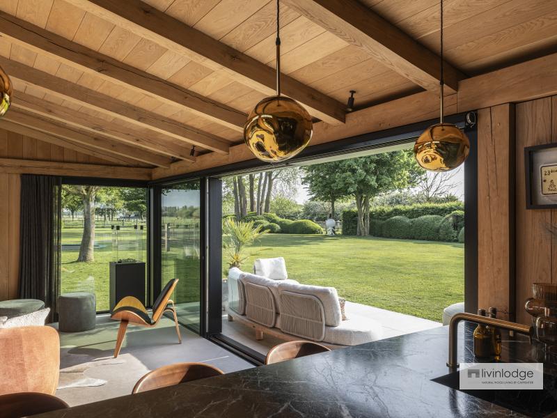 Interior with exposed roof boards and solid oak beams in a modern garden room