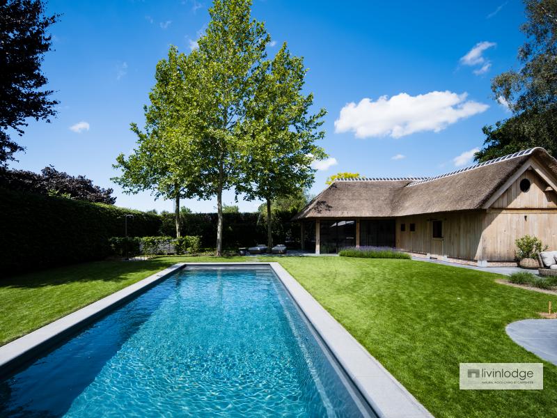 Eiken poolhouse met rieten dak en stalen ramen voor moderne toets